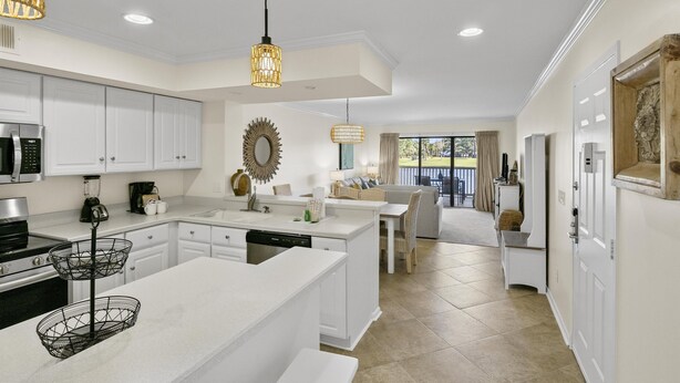 A modern kitchen with white cabinetry, a central island, and pendant lighting. - 1BR Lakefront Condo Sandestin w/ Golf Cart (Miramar Beach)