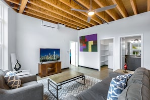 Relax in this stylish living room with a flat-screen TV, comfortable sofa, and patterned rug.