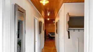 A hallway with wooden flooring, white walls, and a ceiling light fixture. There are doors on the left and a coat rack on the right. - Cozy home in Strömsnäsbruk with WiFi (Strömsnäsbruk)
