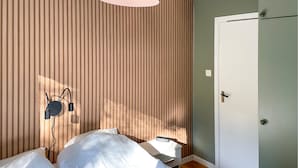 A bedroom with a bed, a bedside table, a wall-mounted lamp, and a door. - Cozy home in Strömsnäsbruk with WiFi (Strömsnäsbruk)