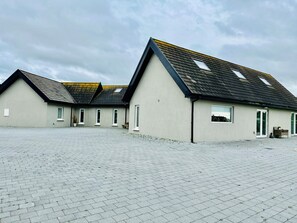 Eine Reihe moderner, eingeschossiger Gebäude mit flachem Dach und zahlreichen Fenstern.