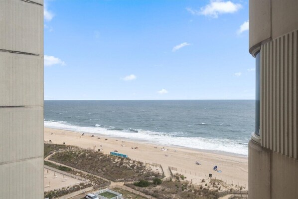 Vista a la playa desde un balcón con cielo despejado.
