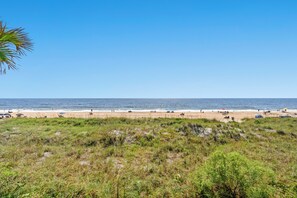 A beach with a clear sky, sandy shore, and sparse vegetation. - Oceanfront Condo with Screened Oceanfront Balcony + Free Attraction Tickets! (North Myrtle Beach)