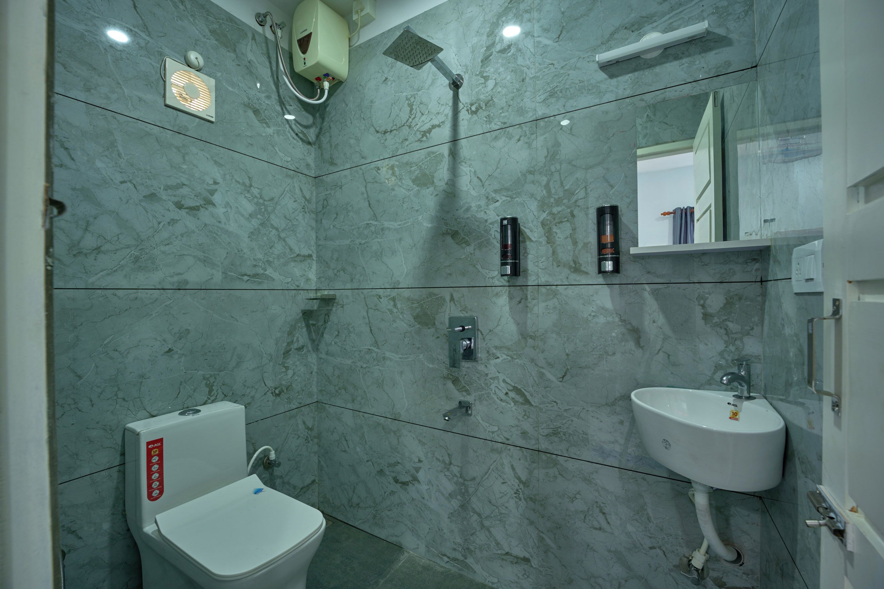 Un baño con inodoro, lavamanos y ducha.