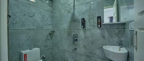 Un baño con inodoro, lavamanos y ducha.