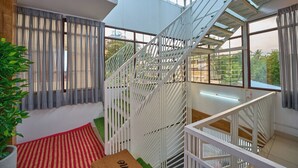 A modern interior with a staircase, large windows, and a red carpet. - Panakal Residency (Kochi)