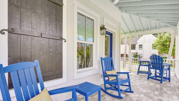 A covered porch with blue furniture and a view of the neighborhood. - 1 Mi to Riverwalk: Brand New Bradenton Home (Bradenton)