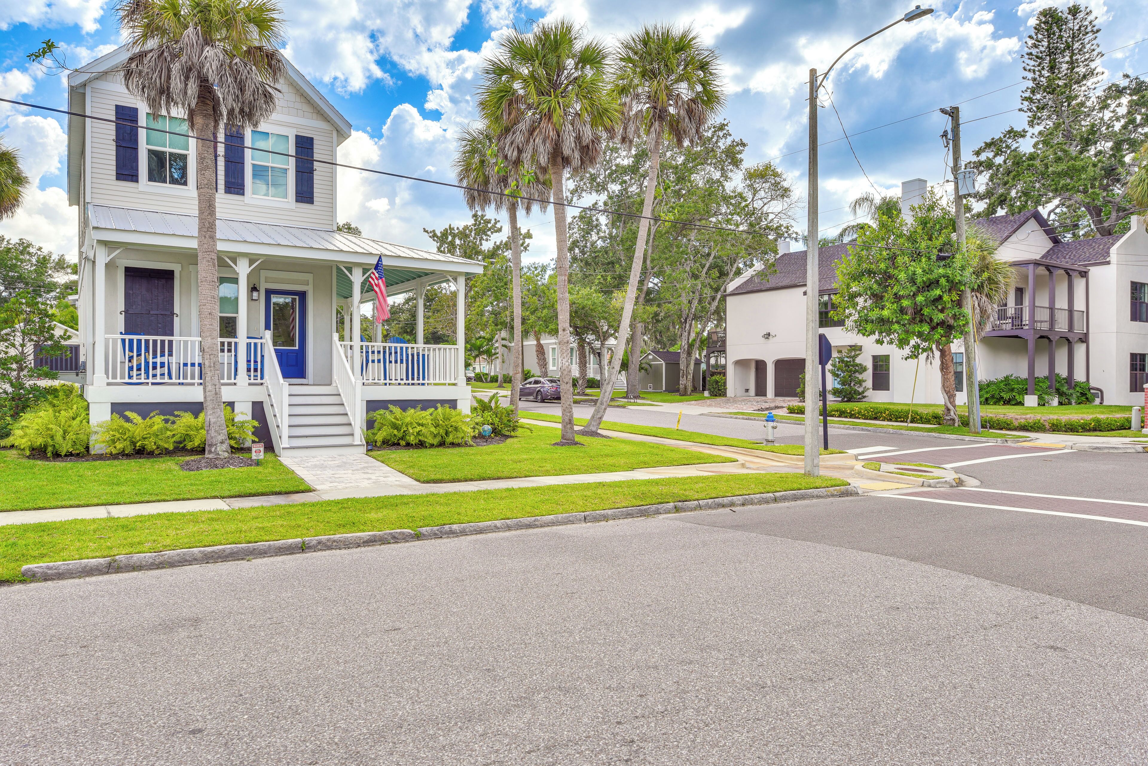 A two-story house with a porch, a flag, and a well-maintained lawn.