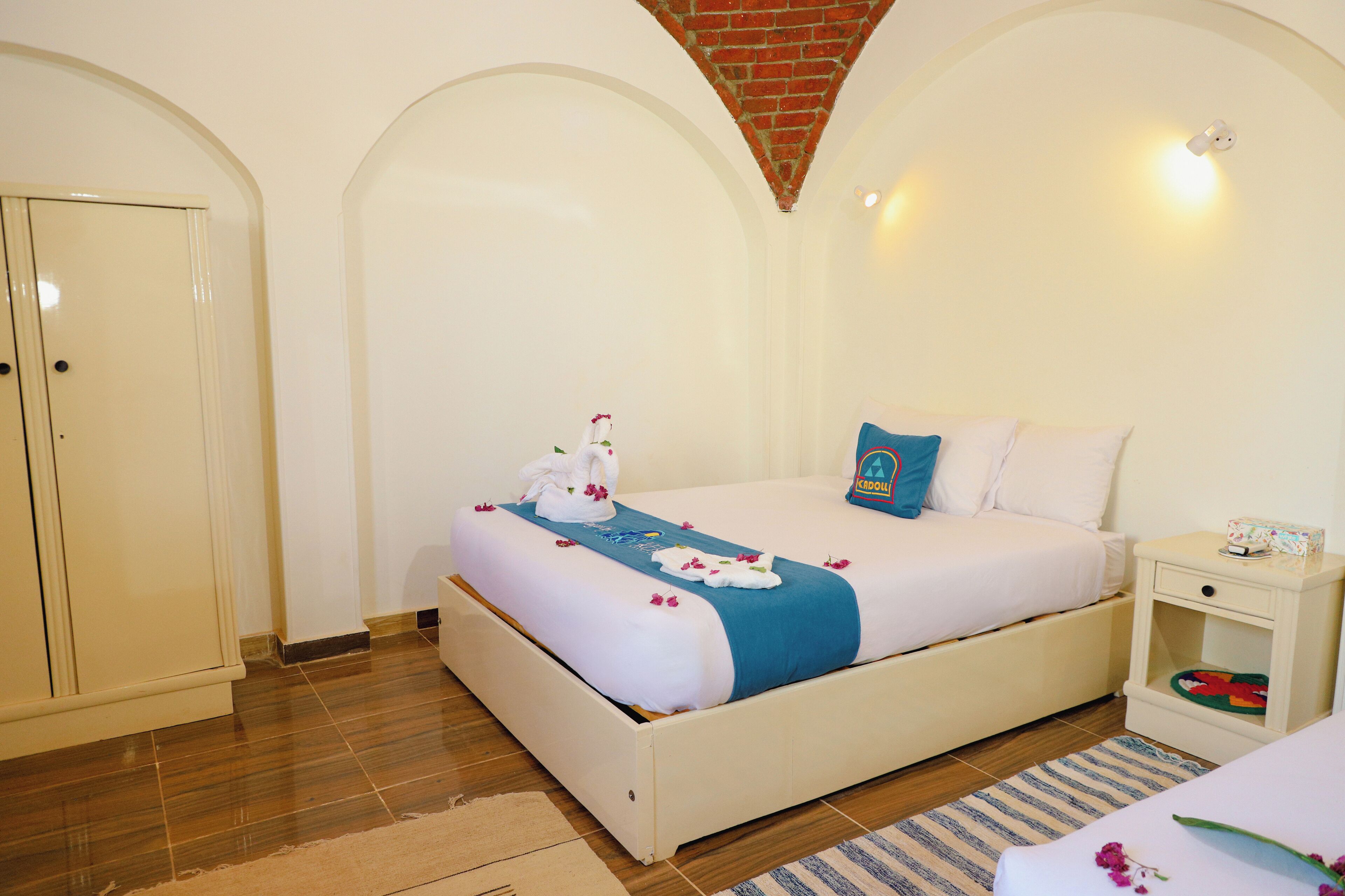A neatly arranged bedroom with a bed, bedside table, and a wardrobe.
