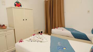 Una habitación de hotel con dos camas, un armario y un objeto decorativo en la pared.