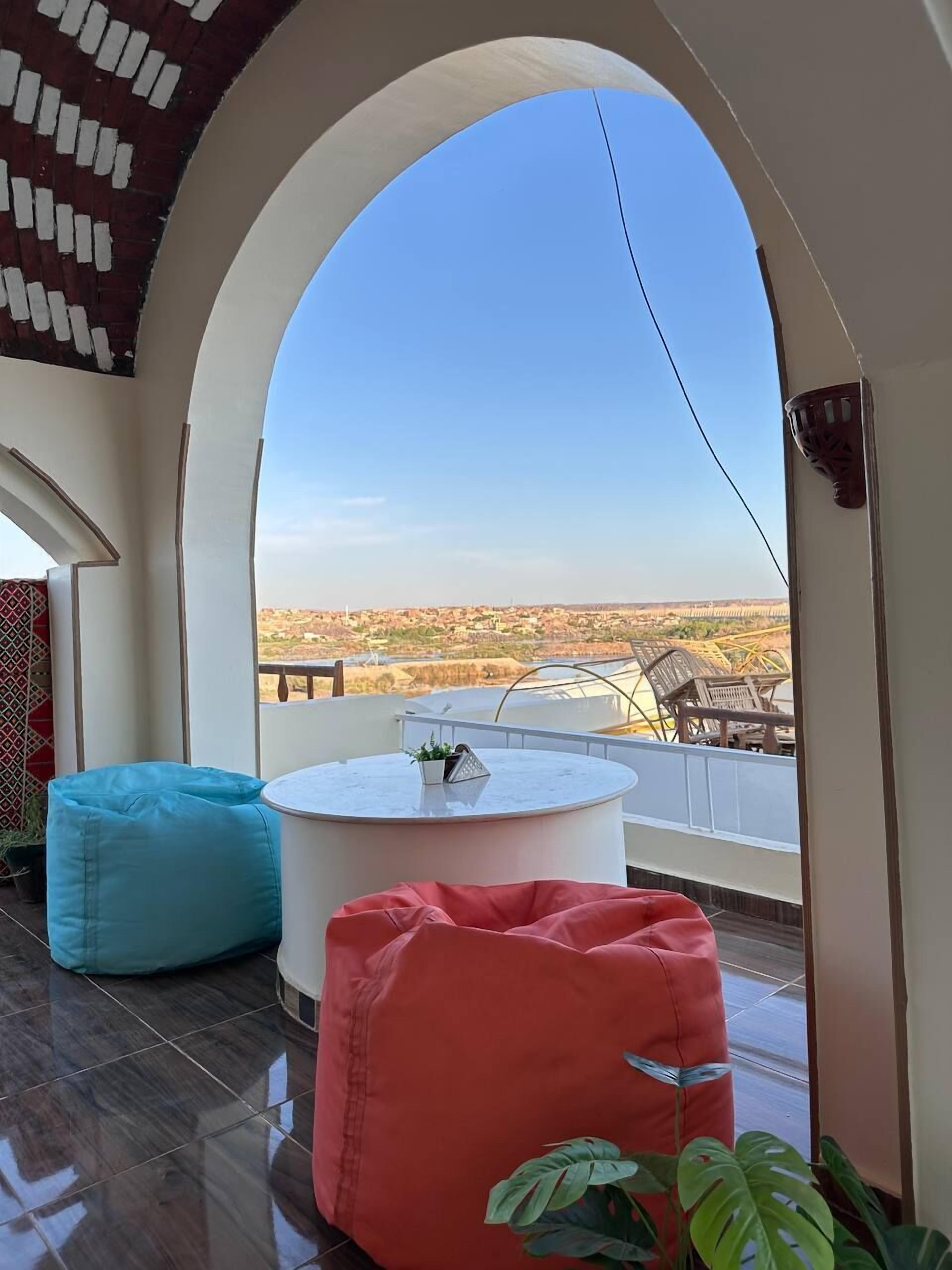 A balcony with a clear view of a distant landscape, a round table, and two bean bags.