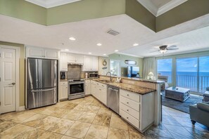 A spacious kitchen with a large island, stainless steel appliances, and a view to the outside. - Treasure Island 804- Heated Pool, Hot Tub, Grills, FREE Golf & Beach Service! (Panama City Beach)