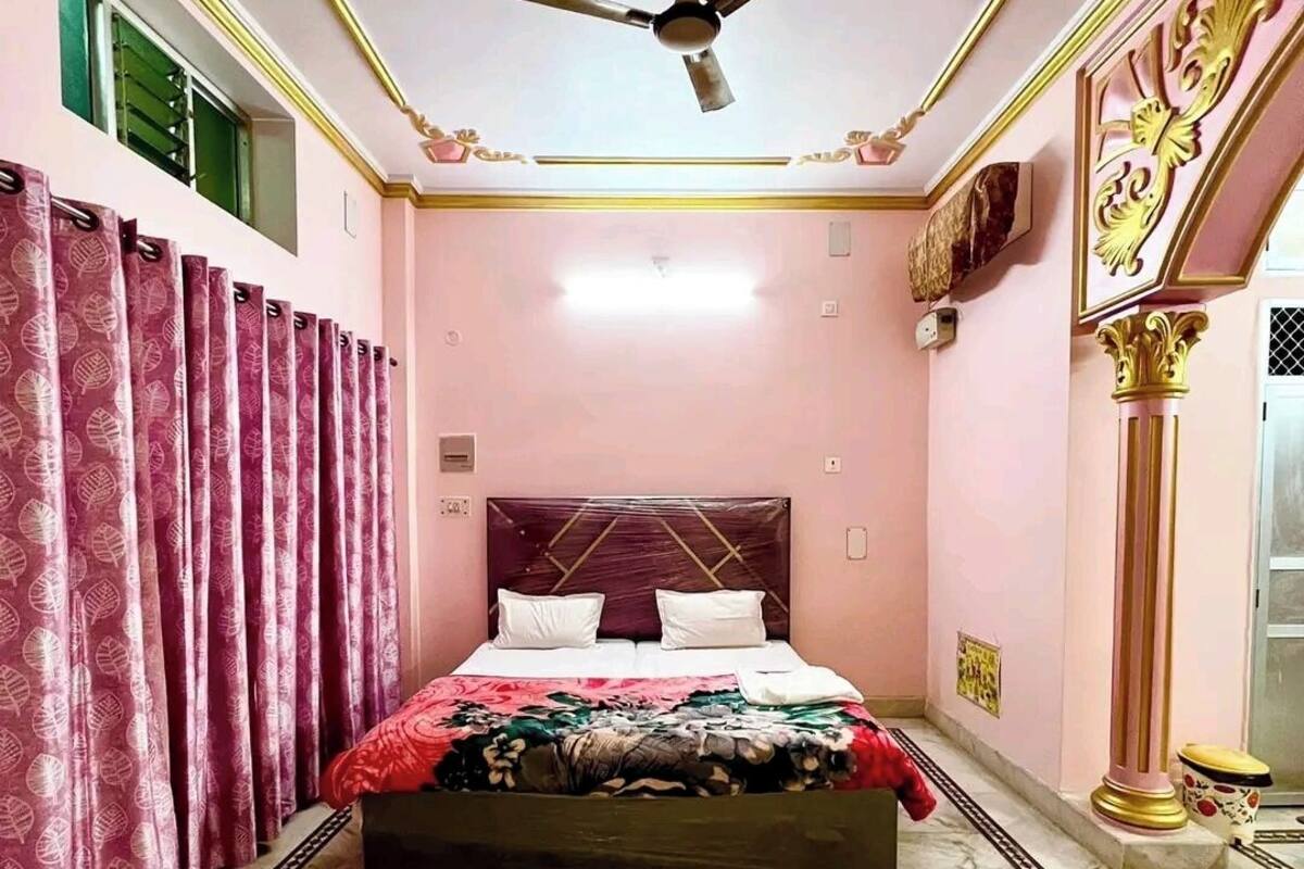 A bedroom with a bed, curtains, a ceiling fan, and a marble floor.
