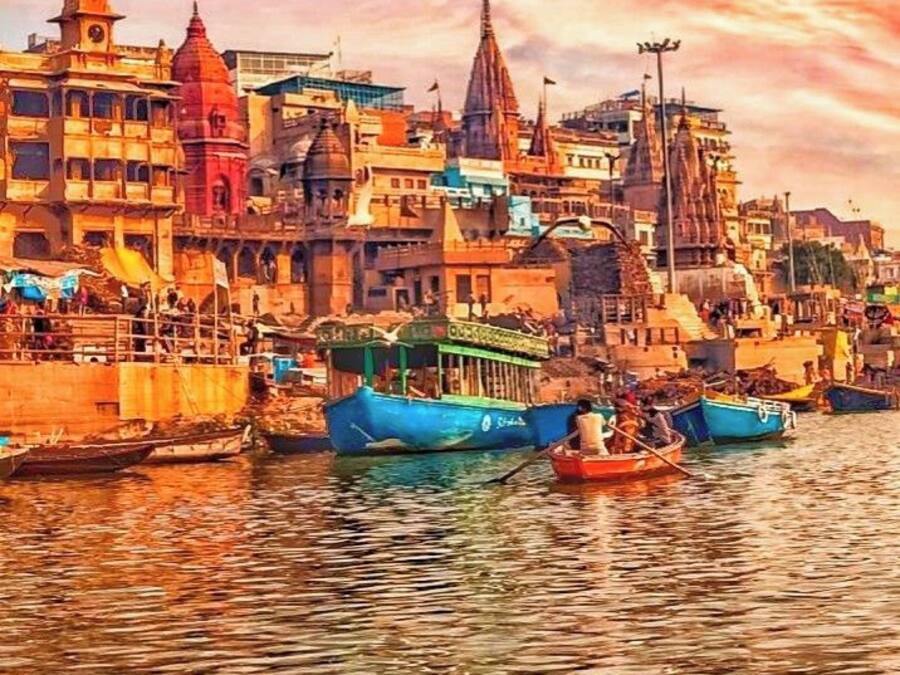 Vista fluvial de una zona urbana densamente poblada con arquitectura tradicional, barcos y cielo despejado.