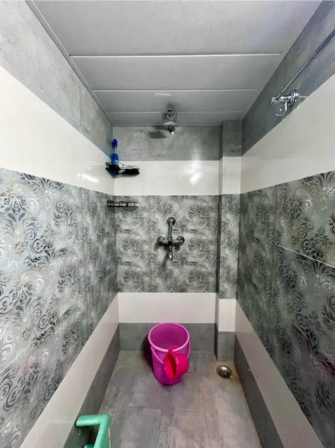 Un baño pequeño con ducha, inodoro y lavamanos.