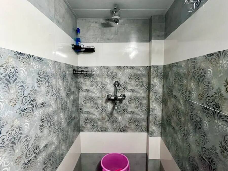 Un baño pequeño con ducha, inodoro y lavamanos.