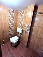 A small bathroom with a toilet, shower, and tiled walls.