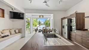 Una cocina moderna con una isla central, electrodomésticos integrados y vistas a un patio exterior.