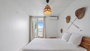 Un dormitorio con una cama grande, una lámpara en el techo y vistas al exterior.