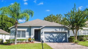 A single-story house with a garage, a front yard with a lawn and a few trees, and a mailbox. - Highgate@Legacy Park, a 3 bed 2 bath pet friendly home within a gated community (Davenport)