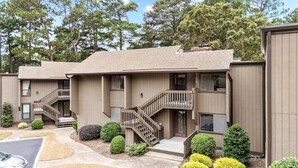 A two-story building with a wooden staircase leading to a balcony. - COMPLETELY REMODELED 3 BDR, 2 Bath, Golf Course View Condo (Pinehurst)
