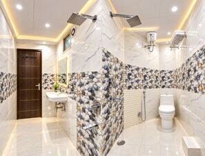 A modern bathroom with a marble floor, a sink, a toilet, and a shower area. - Hotel Happy Stay - Delhi Airport (New Delhi)