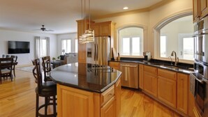 A modern kitchen with wooden cabinets, stainless steel appliances, and a central island. - "Endless Summer" Waterfront on the Chesapeake Bay! (Woolford)
