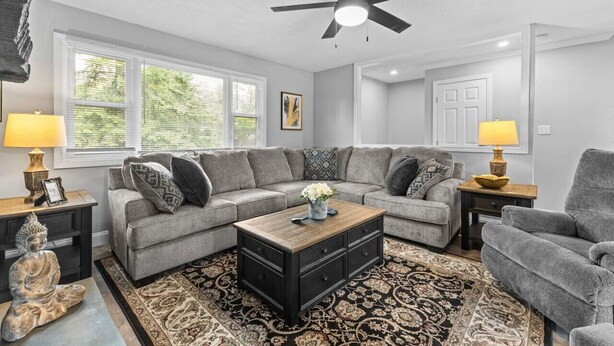A living room with a sectional sofa, a coffee table, and a ceiling fan. - Cute 3BR APT - So Burlington (South Burlington)