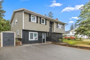 Une maison à deux étages avec un garage, une allée couverte et un escalier menant au deuxième étage.