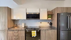Una cocina moderna con estufa a gas, electrodomésticos de acero inoxidable y muebles de madera.