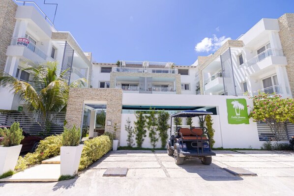 A modern building with a gated entrance, a golf cart, and a sign indicating a restaurant.