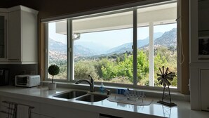 A kitchen with a large window offering a view of a mountainous landscape. - Beulah Land Only 4 Miles from SNP! (Three Rivers)