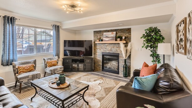 A living room with a fireplace, a TV, and a sofa. - Spacious Home Near Tennyson & Olde Towne - Sauna + Massage Chair + WiFi (Arvada)