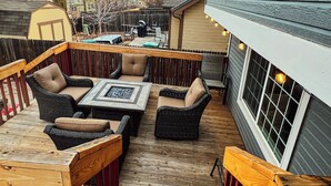 A wooden deck with outdoor furniture, including sofas and a table, surrounded by a wooden fence. - Spacious Home Near Tennyson & Olde Towne - Sauna + Massage Chair + WiFi (Arvada)