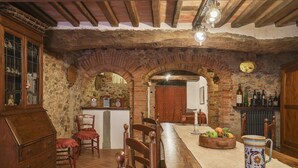 A rustic interior with exposed brick arches, wooden furniture, a long dining table, and a wine rack. - Room 'Ginepro Double  - First Floor' with Shared Terrace and Wi-Fi (Montecarlo)