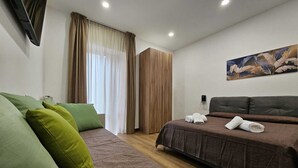 Ein modernes Schlafzimmer mit einer Couch, einem Bett, einem Holzschrank und einem Bild an der Wand.