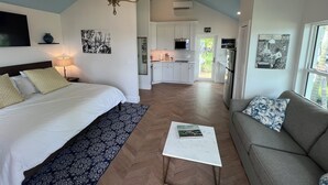 A bedroom with a bed, a nightstand, a chandelier, a sofa, and a coffee table.