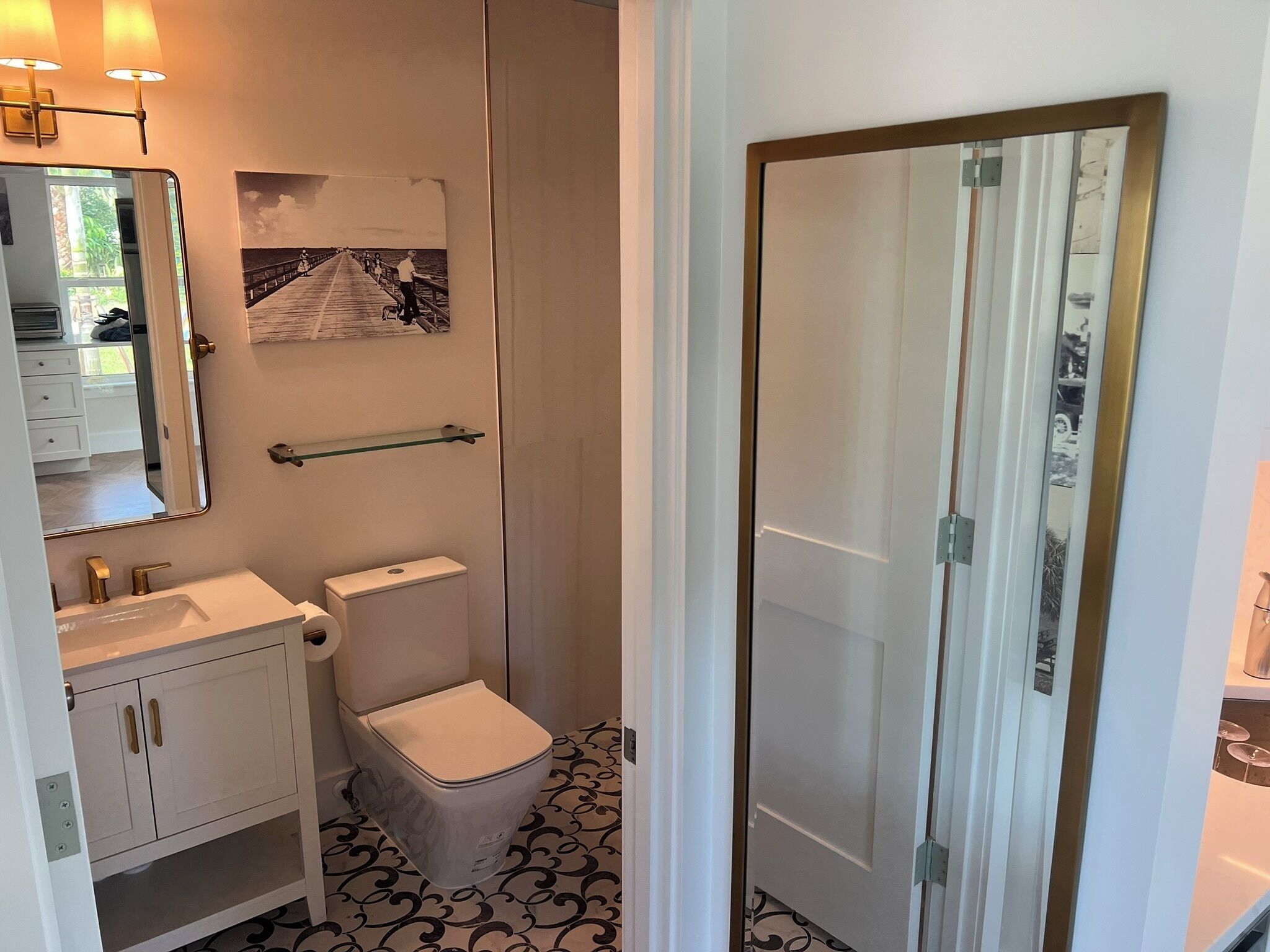 A bathroom with a white sink, toilet, and a glass shower door.