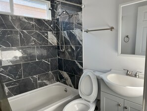 Chuveiro, banheira de hidromassagem, secador de cabelo, toalhas de banho
