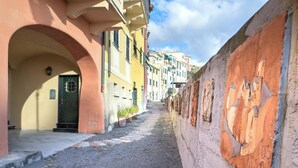 Una estrecha calle flanqueada por edificios, un camino empedrado y una pared con adornos tallados.