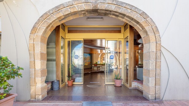 An entrance with a stone archway, glass doors, and potted plants. - Studio 'Flat Blu Palermo Mondello' with Shared Pool, Shared Terrace & Air Conditioning (Palermo)