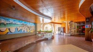 A spacious lobby with a mural, potted plants, and a tiled floor. - Studio 'Flat Blu Palermo Mondello' with Shared Pool, Shared Terrace & Air Conditioning (Palermo)