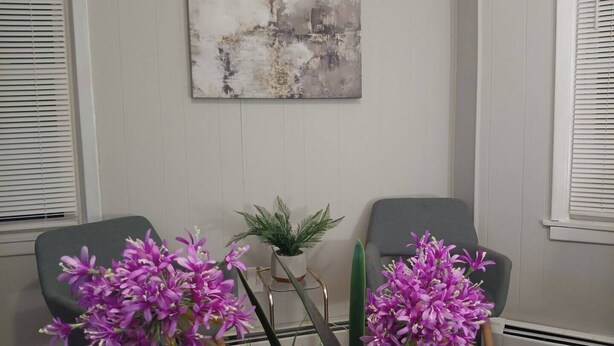 A room with two gray armchairs, a potted plant, and a large abstract painting on the wall. - The Town-Suite at Wanskuck NEW 2-BR APT  Parking (Povidence)