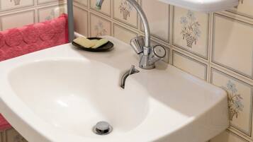 A white sink with a chrome faucet and a soap dish.