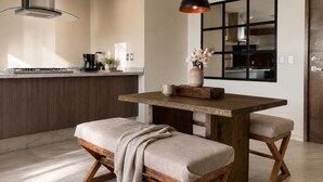 A modern kitchen with a wooden dining table, bench seating, and a pendant light. - CityView 2 BedRoom / Daily cleaning (Guadalajara)