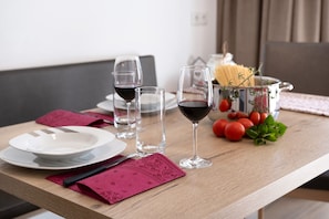 Una mesa de comedor con platos, vasos y un recipiente con pasta.