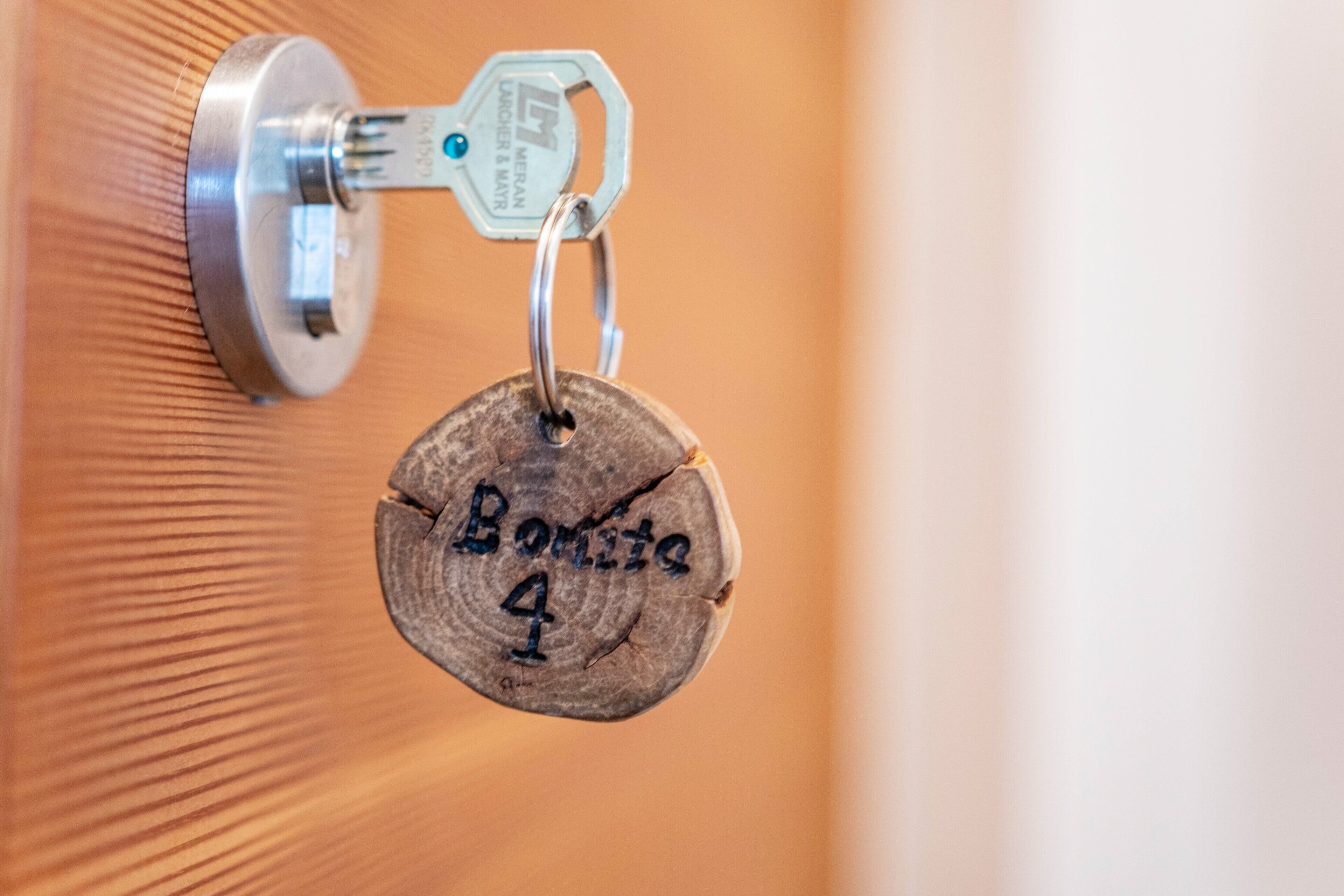Un porte-clés avec une étiquette en bois fixée à une serrure de porte.