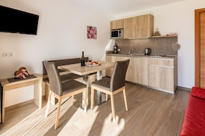 Eine moderne Küche mit Holzschränken, einer Mikrowelle und einer Kaffeemaschine.