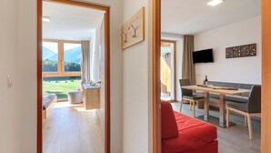 Ein modernes Interieur mit Essbereich, einem roten Sofa und einem an der Wand befestigten Fernseher.