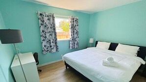A bedroom with a bed, a desk, a lamp, and curtains. - Cozy 3BR Home Near SF & Napa Valley (Vallejo)